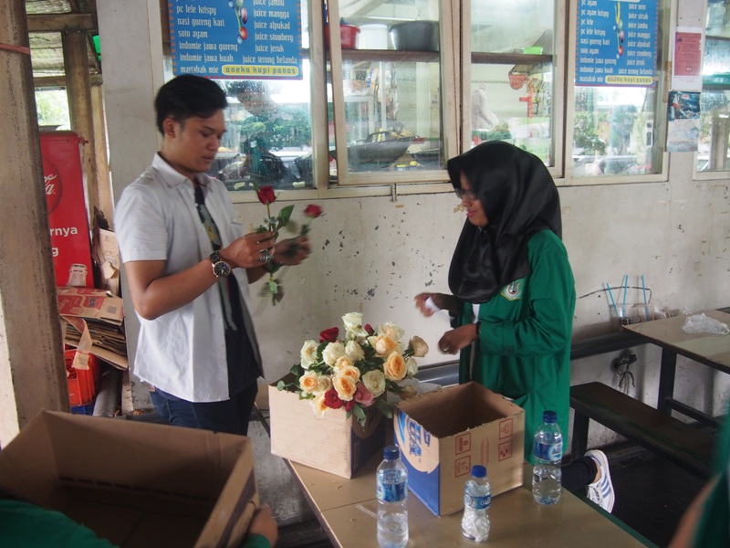 Mahasiswa anggota Himpunan Mahasiswa Hubungan Internasional mempersiapkan bunga yang akan dijual sebagai bentuk penggalangan dana